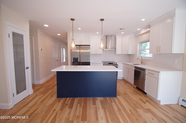 kitchen featuring appliances with stainless steel finishes, wall chimney exhaust hood, a sink, a center island, and tasteful backsplash