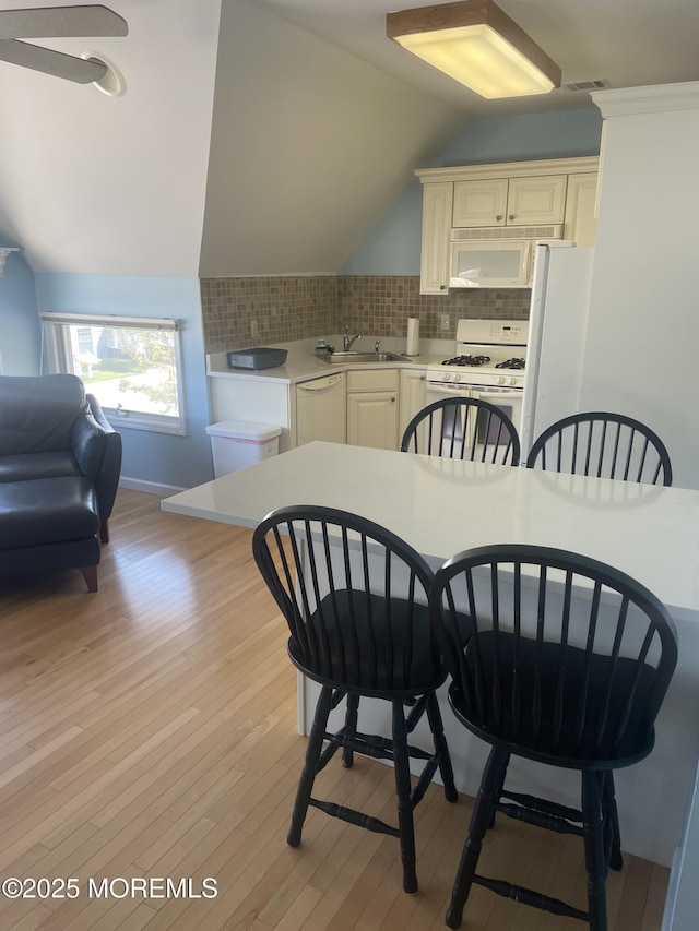 100 Vance Ave, Lavallette, NJ 08735 - kitchen featuring white appliances, lofted ceiling, light countertops, light wood-style floors, and decorative backsplash
