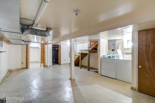 below grade area featuring washer and clothes dryer, electric panel, stairs, and light flooring
