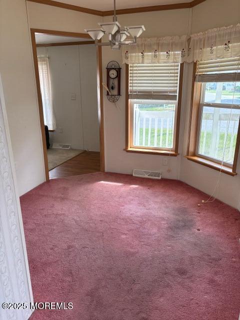 unfurnished room with carpet and a chandelier