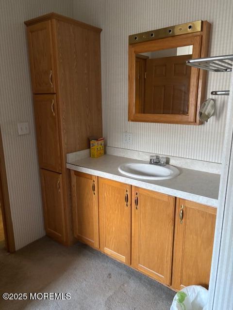 bathroom featuring wallpapered walls and vanity