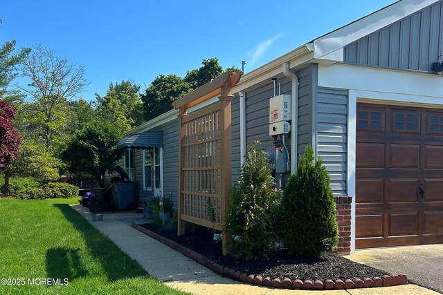 23 Lambeth Ln, Manchester, NJ 08759 - view of home's exterior with board and batten siding, a lawn, and an attached garage