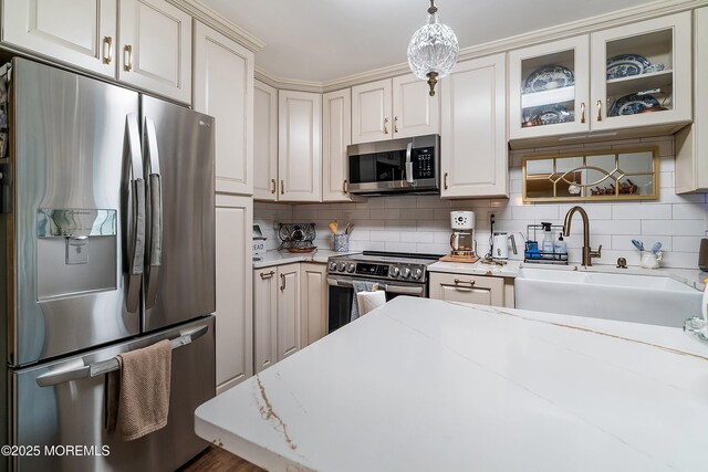 23 Lambeth Ln, Manchester, NJ 08759 - kitchen featuring appliances with stainless steel finishes, tasteful backsplash, decorative light fixtures, glass insert cabinets, and a sink