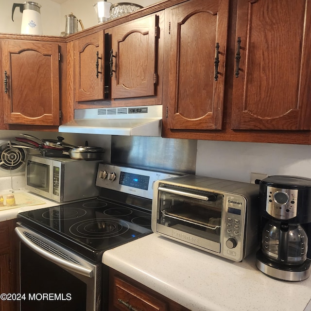 6 Conestoga Dr Unit C, Whiting, NJ 08759 - kitchen with stainless steel appliances, under cabinet range hood, light countertops, and brown cabinets