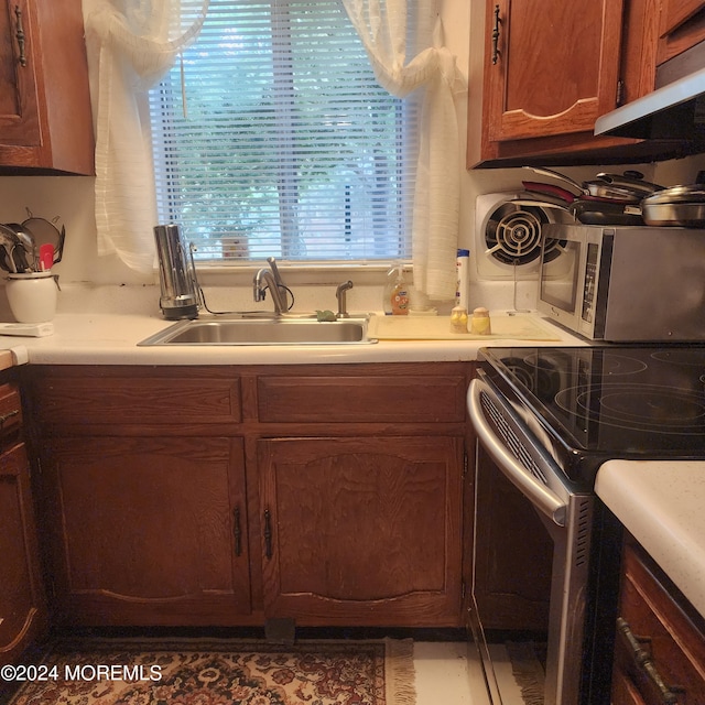 6 Conestoga Dr Unit C, Whiting, NJ 08759 - kitchen featuring appliances with stainless steel finishes, a sink, light countertops, under cabinet range hood, and brown cabinetry