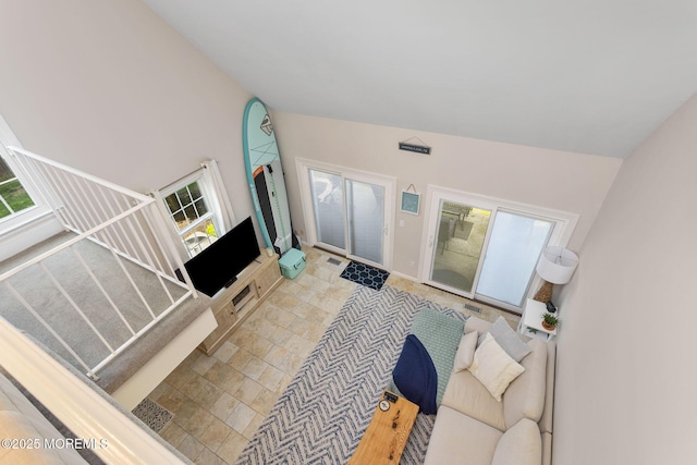 living area featuring lofted ceiling and stairs