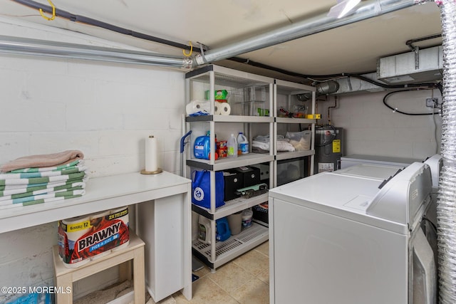 laundry area featuring electric water heater, separate washer and dryer, concrete block wall, and light tile patterned flooring