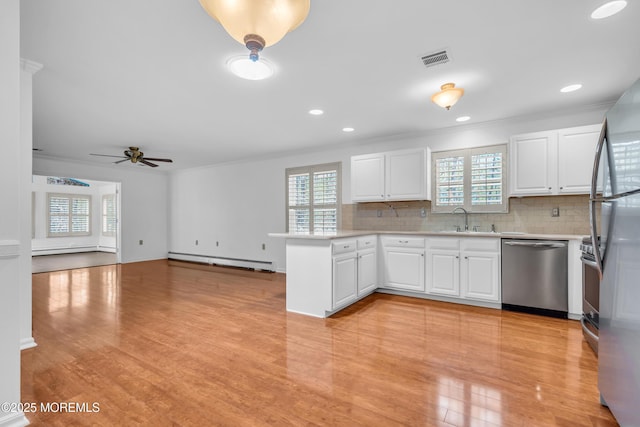 235 Prince Charles Ct, Toms River, NJ 08757 - kitchen with stainless steel appliances, a sink, baseboard heating, a peninsula, and crown molding