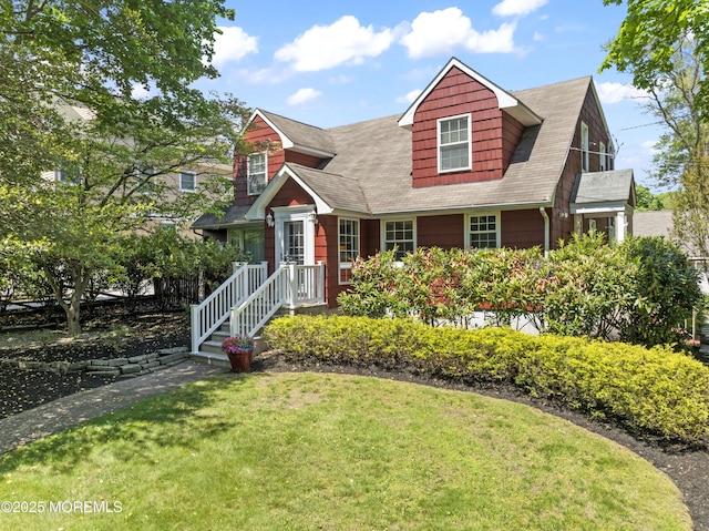 view of front facade featuring a front lawn and a shingled roof