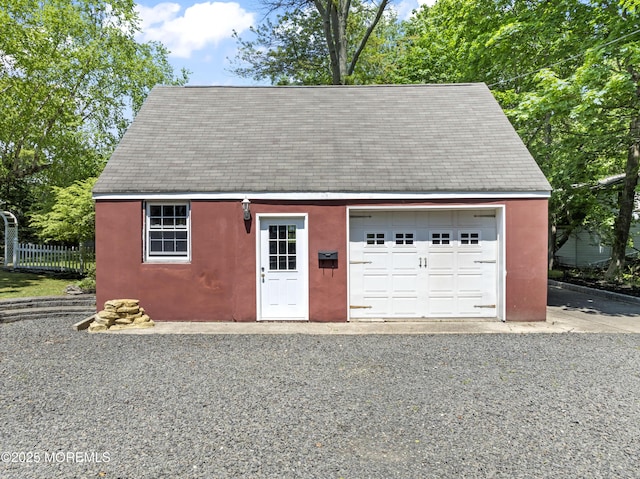 detached garage featuring fence