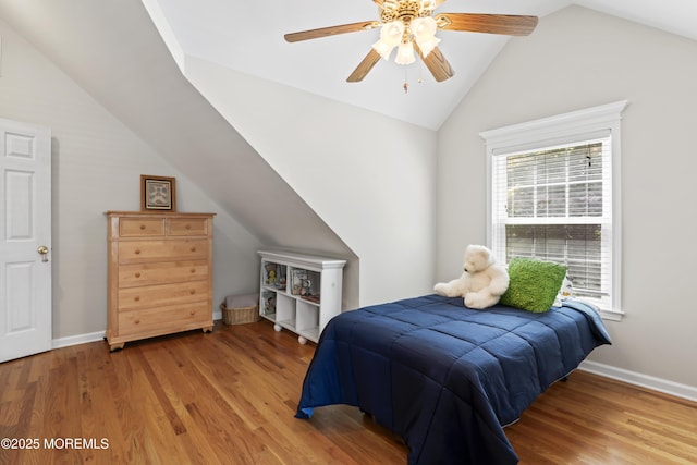 bedroom with vaulted ceiling, light wood finished floors, baseboards, and ceiling fan