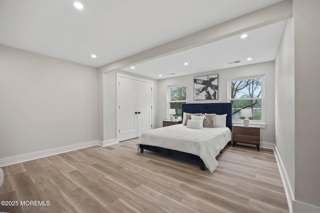 bedroom with light wood-style flooring, baseboards, recessed lighting, and a closet