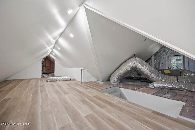bonus room featuring vaulted ceiling and wood finished floors