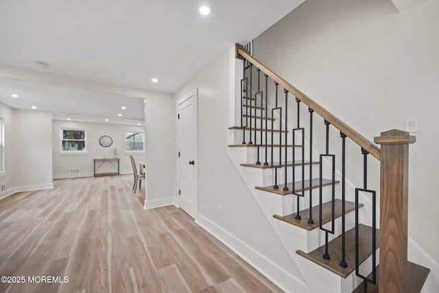 staircase with wood finished floors, recessed lighting, and baseboards
