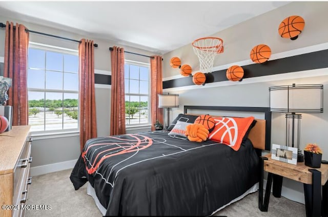 bedroom with light colored carpet, multiple windows, and baseboards