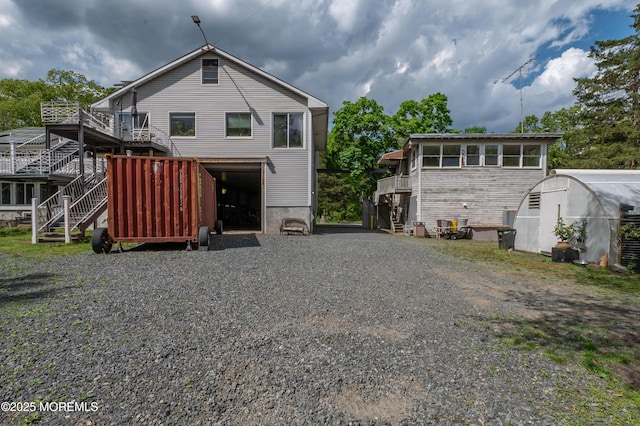 144-146 E Greystone Rd, Old Bridge, NJ 08857 - rear view of house featuring stairs, gravel driveway, a deck, and a garage