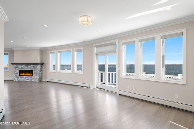 unfurnished living room featuring a baseboard heating unit, a baseboard radiator, ornamental molding, wood finished floors, and recessed lighting