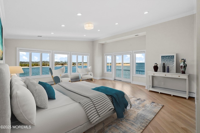 bedroom featuring a baseboard heating unit, ornamental molding, multiple windows, wood finished floors, and access to outside