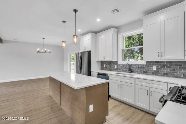 7 Leifried Ln, Tuckerton, NJ 08087 - kitchen with freestanding refrigerator, a sink, a kitchen island, tasteful backsplash, and plenty of natural light