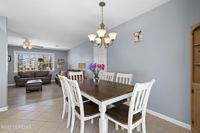 dining space with a chandelier, light tile patterned flooring, baseboards, and a ceiling fan