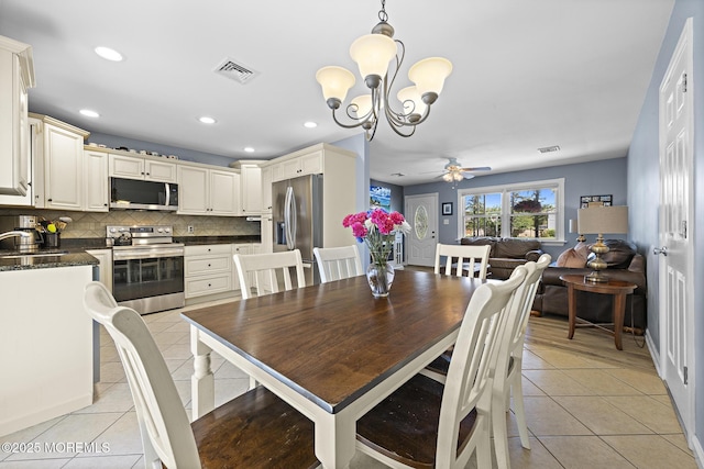 dining area with light tile patterned floors, a ceiling fan, a chandelier, and recessed lighting