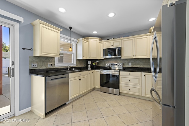 kitchen with stainless steel appliances, cream cabinets, a sink, plenty of natural light, and recessed lighting