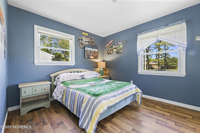 bedroom with wood finished floors and baseboards
