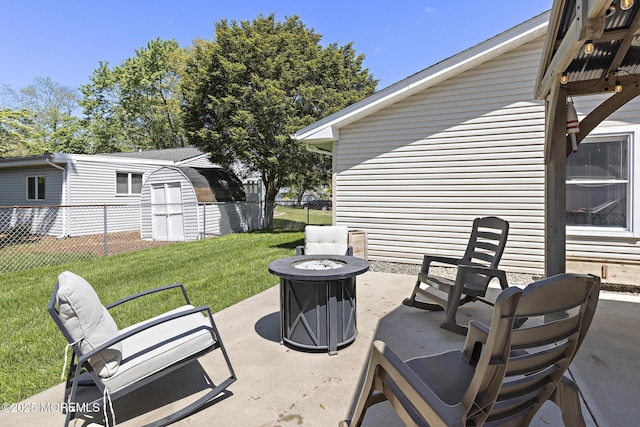 view of patio / terrace with a fire pit, a storage unit, and an outbuilding