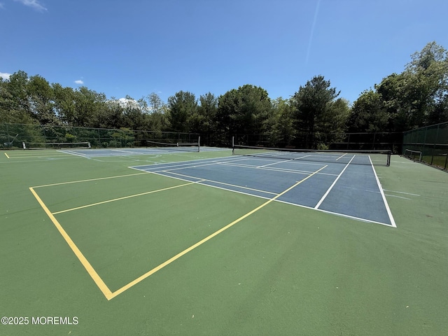 view of tennis court featuring fence and community basketball court