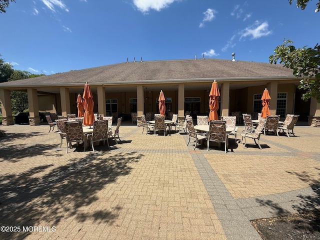 back of property featuring outdoor dining area and a patio area