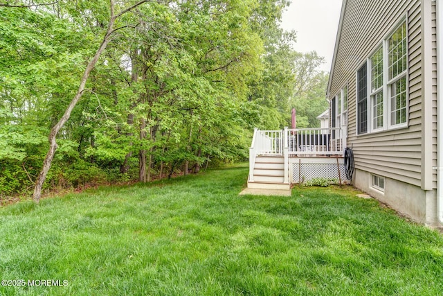 view of green lawn with a wooden deck