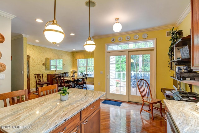 kitchen with wood finished floors, ornamental molding, baseboards, decorative light fixtures, and light stone counters