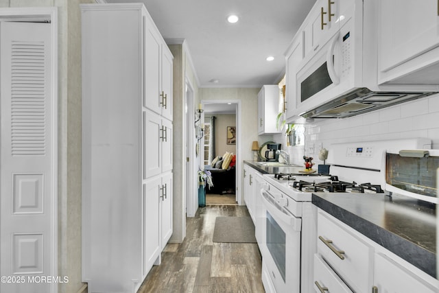 16 Bayshore Mobile Mnr, Hazlet, NJ 07730 - kitchen featuring white appliances, light wood-type flooring, dark countertops, white cabinetry, and recessed lighting