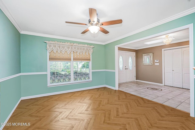 foyer entrance featuring baseboards, ceiling fan, crown molding, and a chandelier
