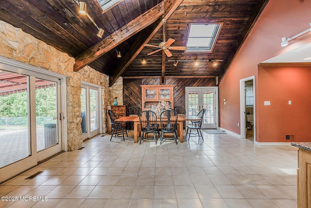 dining space featuring high vaulted ceiling, a skylight, wooden ceiling, ceiling fan, and light tile patterned flooring