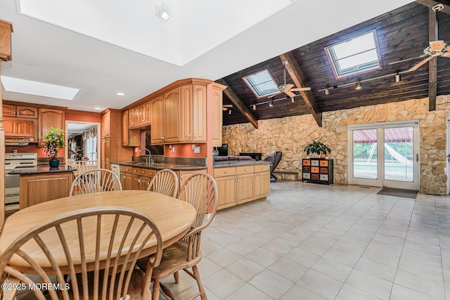 kitchen featuring a skylight, range with electric cooktop, dark countertops, under cabinet range hood, and beamed ceiling