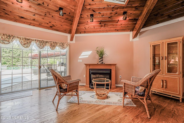sitting room featuring wooden ceiling, a glass covered fireplace, light wood finished floors, crown molding, and baseboards