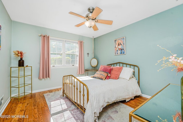 bedroom with wood finished floors, baseboards, and ceiling fan