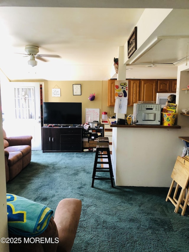 living room featuring a ceiling fan and dark colored carpet