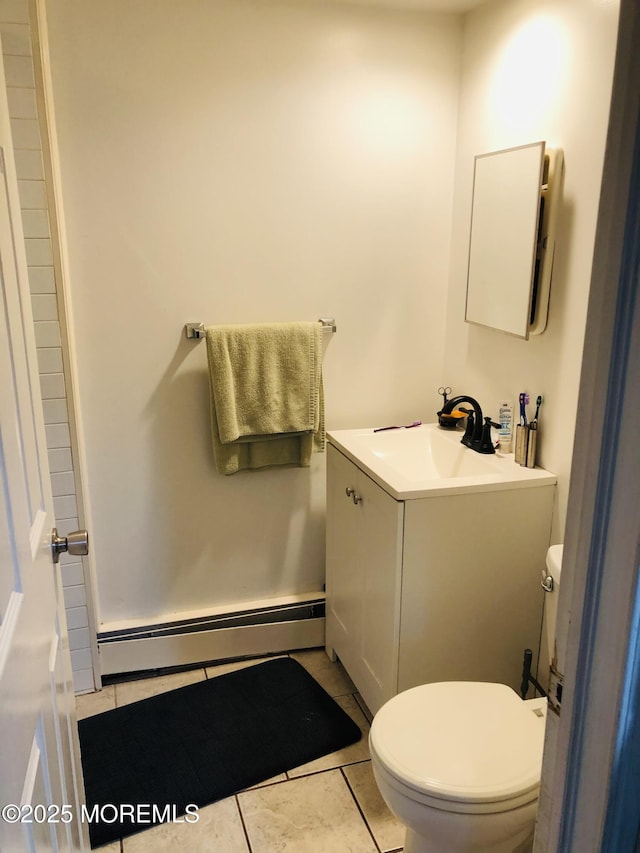 bathroom featuring a baseboard heating unit, toilet, and tile patterned floors