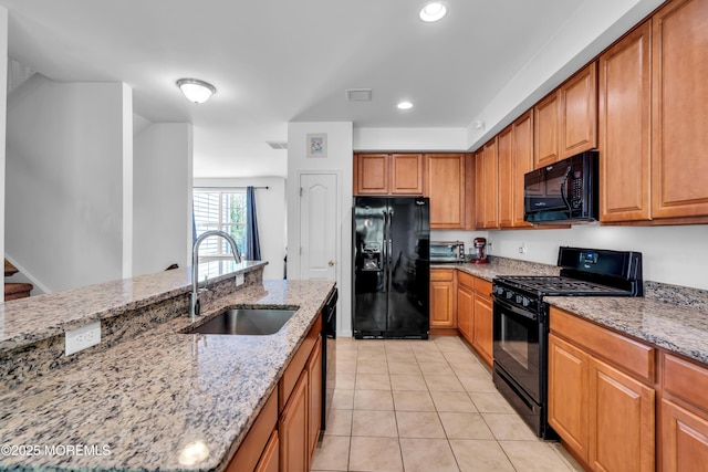 kitchen with black appliances, a sink, light stone countertops, light tile patterned floors, and recessed lighting