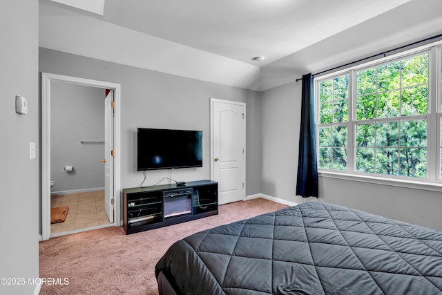 carpeted bedroom featuring multiple windows, baseboards, and ensuite bathroom