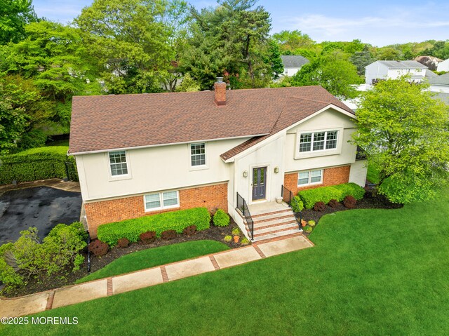 9 Darien Dr, West Long Branch, NJ 07764 - view of front of property featuring a chimney, brick siding, a front lawn, and stucco siding