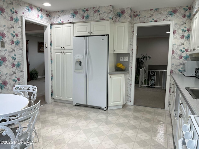 9 Darien Dr, West Long Branch, NJ 07764 - kitchen with white appliances, wallpapered walls, light flooring, white cabinets, and a sink