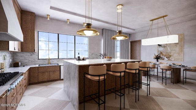 78 Beechwood Ave, West Long Branch, NJ 07764 - kitchen with wall chimney range hood, stainless steel gas cooktop, a center island, a breakfast bar area, and light countertops