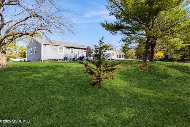 view of green lawn with cooling unit