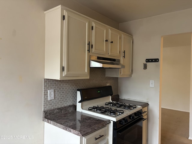 kitchen with under cabinet range hood, range with gas cooktop, and decorative backsplash