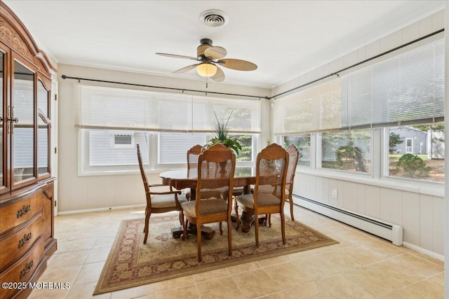 sunroom featuring baseboard heating, healthy amount of natural light, tile patterned flooring, baseboards, and ornamental molding