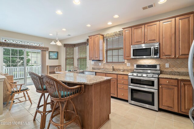 4 Augusta Dr, Little Egg Harbor, NJ 08087 - kitchen featuring appliances with stainless steel finishes, tasteful backsplash, light stone counters, a center island, and recessed lighting
