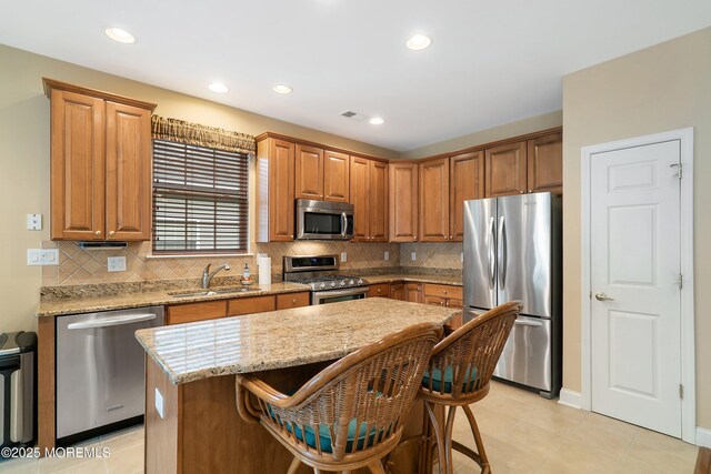 4 Augusta Dr, Little Egg Harbor, NJ 08087 - kitchen featuring appliances with stainless steel finishes, a sink, light stone countertops, a kitchen island, and a kitchen bar